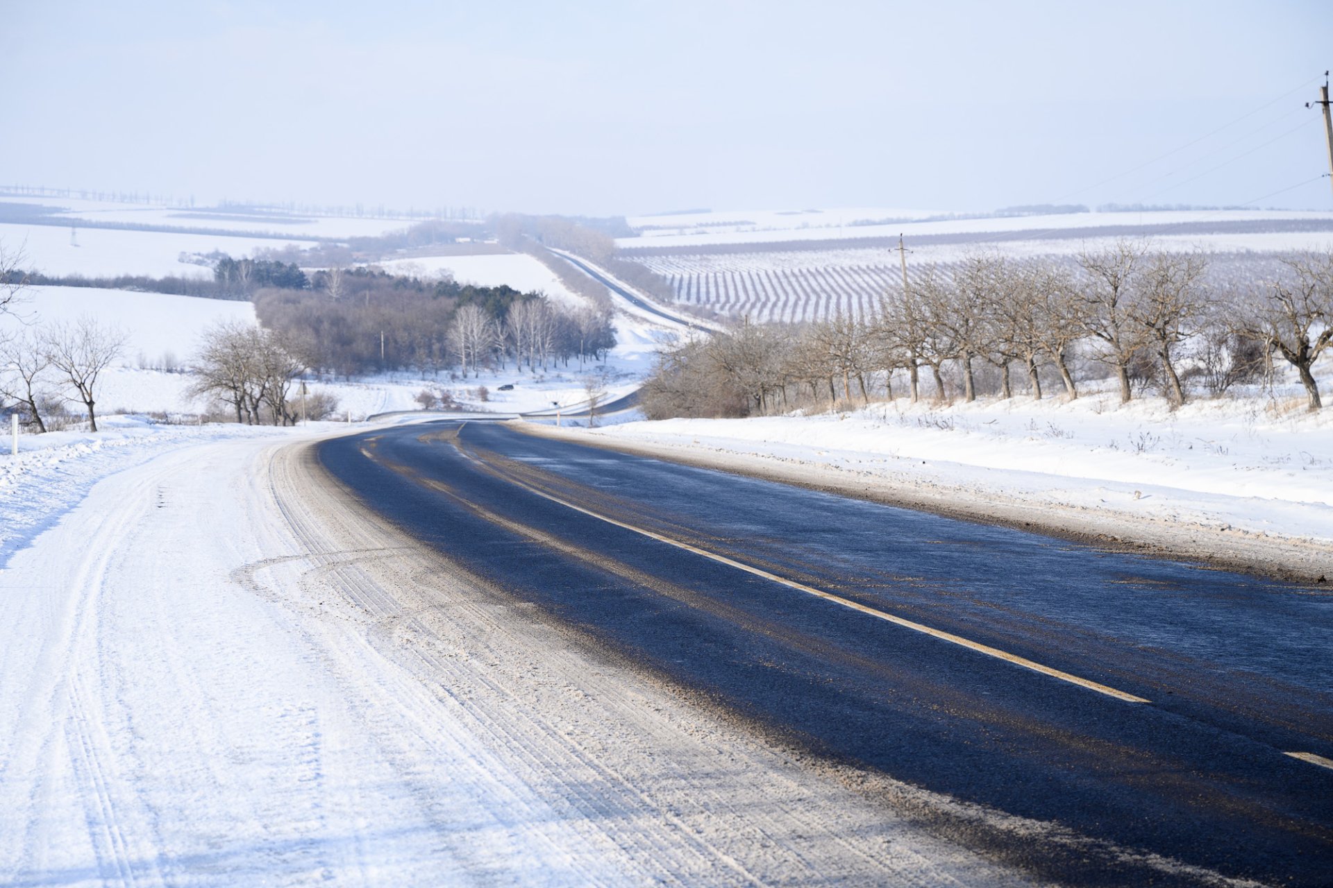 VIDEO // Pe traseele naționale se circulă în condiții de iarnă. Muncitorii intervin pentru a preveni formarea poleiului